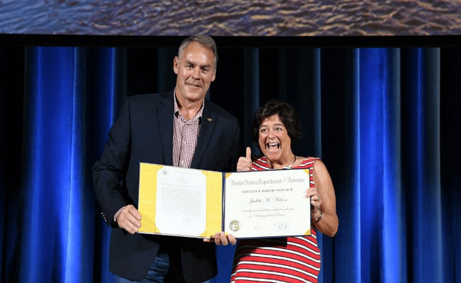 Photo of Judy Wilson accepting an award from Department Secretary Ryan Zinke